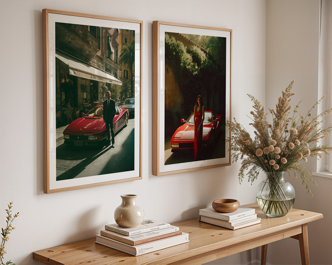 Two framed artworks of red cars on a wall above a wooden console table with decorative items.