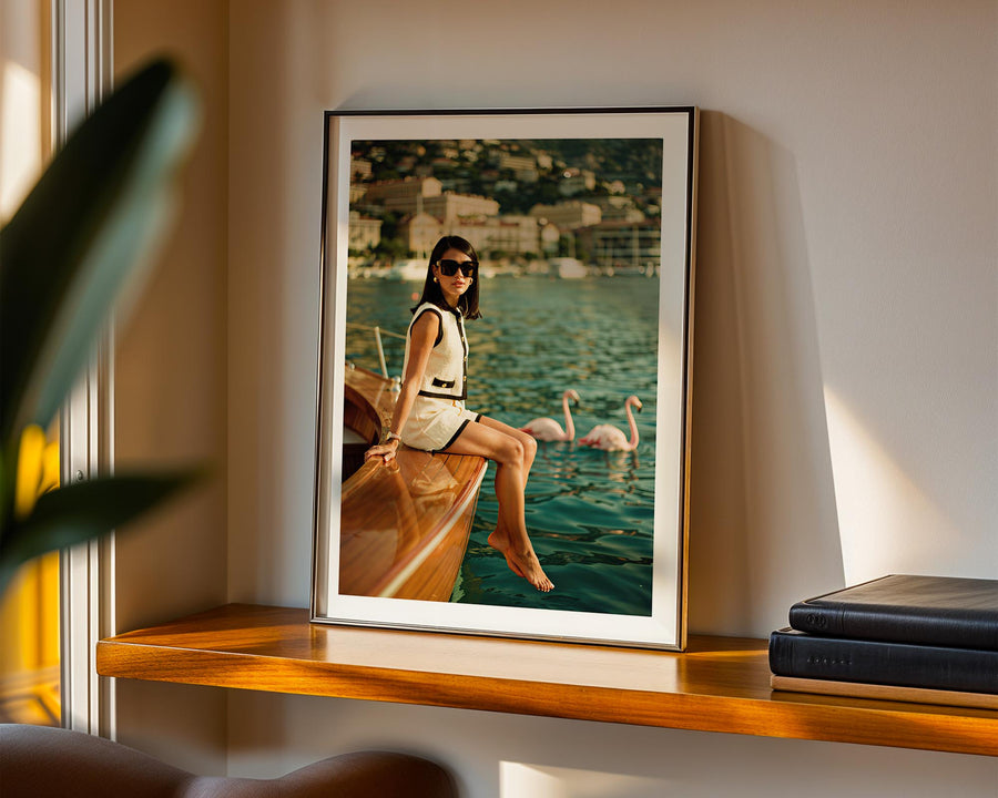 Framed photograph of a woman on a boat with a scenic background, displayed on a shelf.