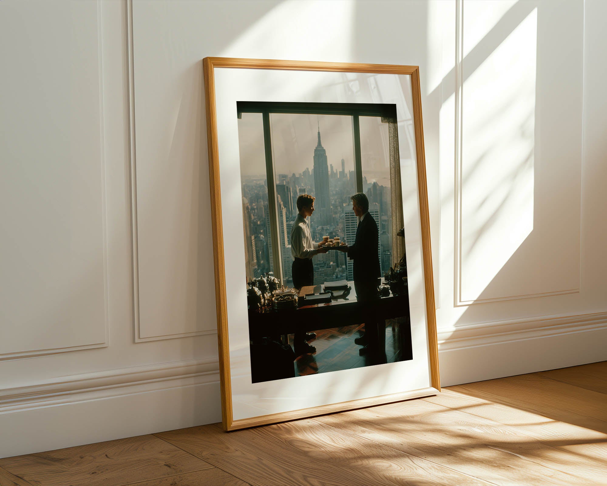 Framed photograph of two people in a room with large windows, sunlight streaming in.