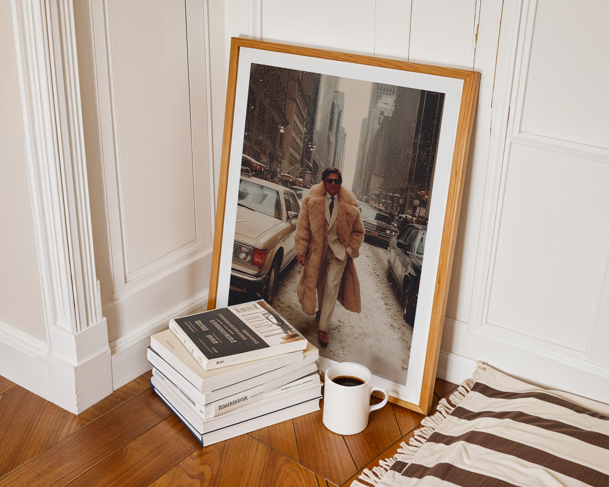 Framed photograph of a person in a coat leaning against a wall, next to books and a coffee cup on a wooden floor.
