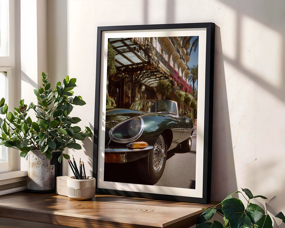 Framed photograph of a classic car on a wooden shelf with plants