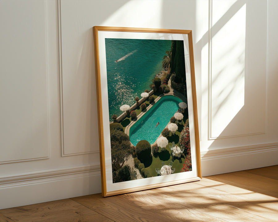 Framed artwork of a pool scene on a wall with sunlight casting shadows.