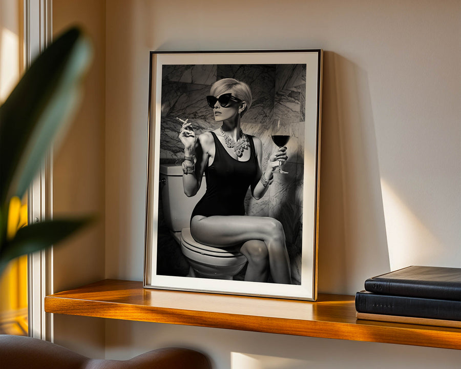 Framed black and white art print of a woman on a shelf with books and a plant.