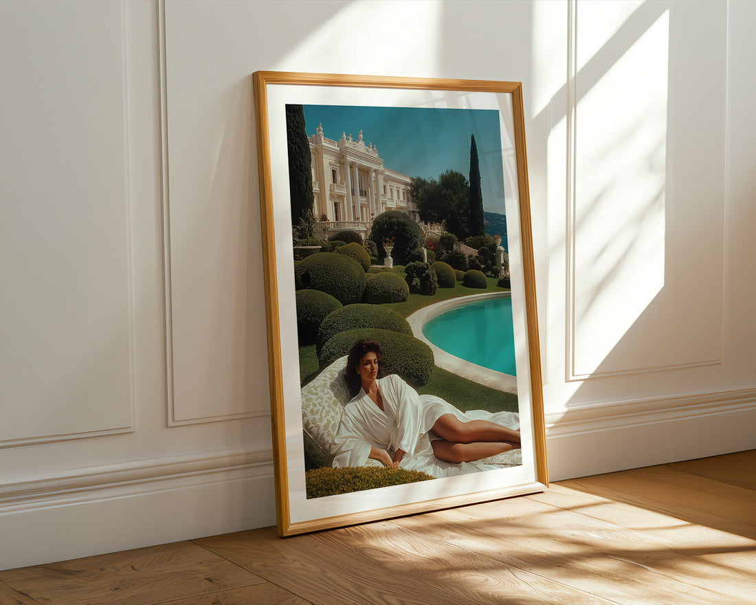 Framed artwork of a woman in a garden with a pool and classical building.