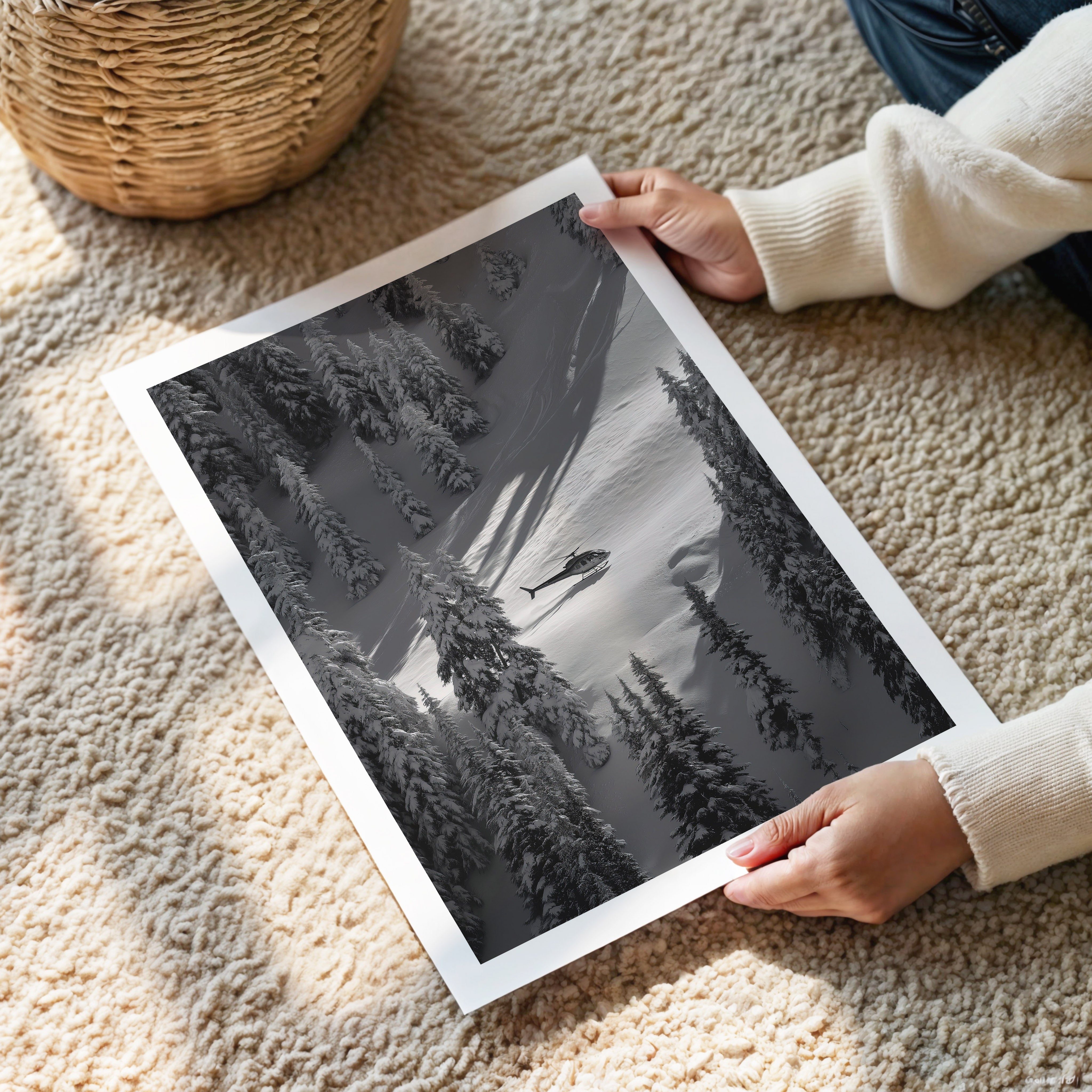 Person holding a black and white landscape print of trees and water on a carpeted floor.