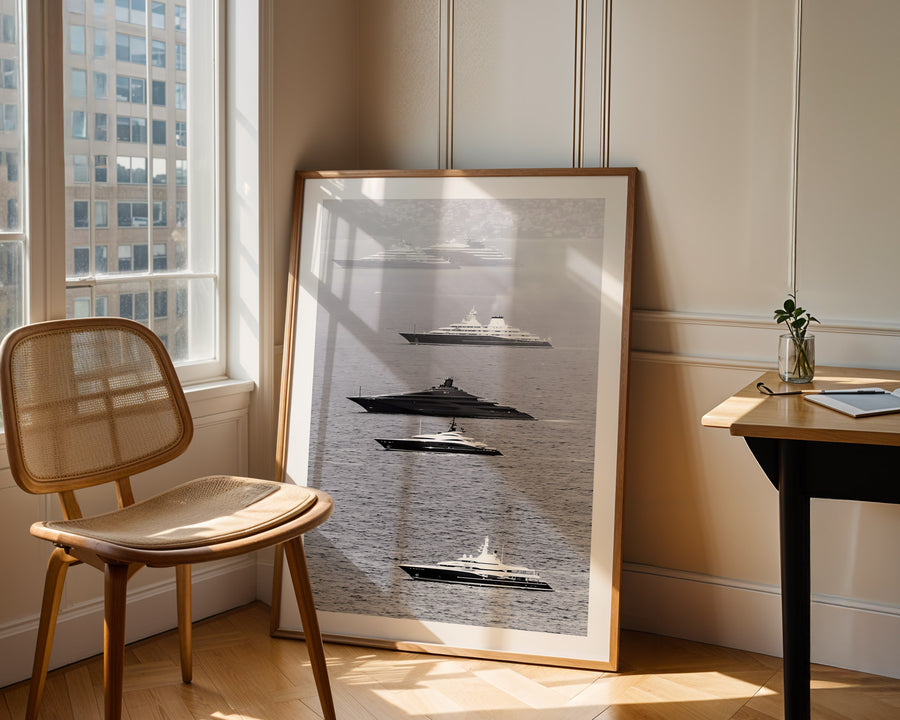 Framed artwork of submarines on a wall in a room with a chair and table.
