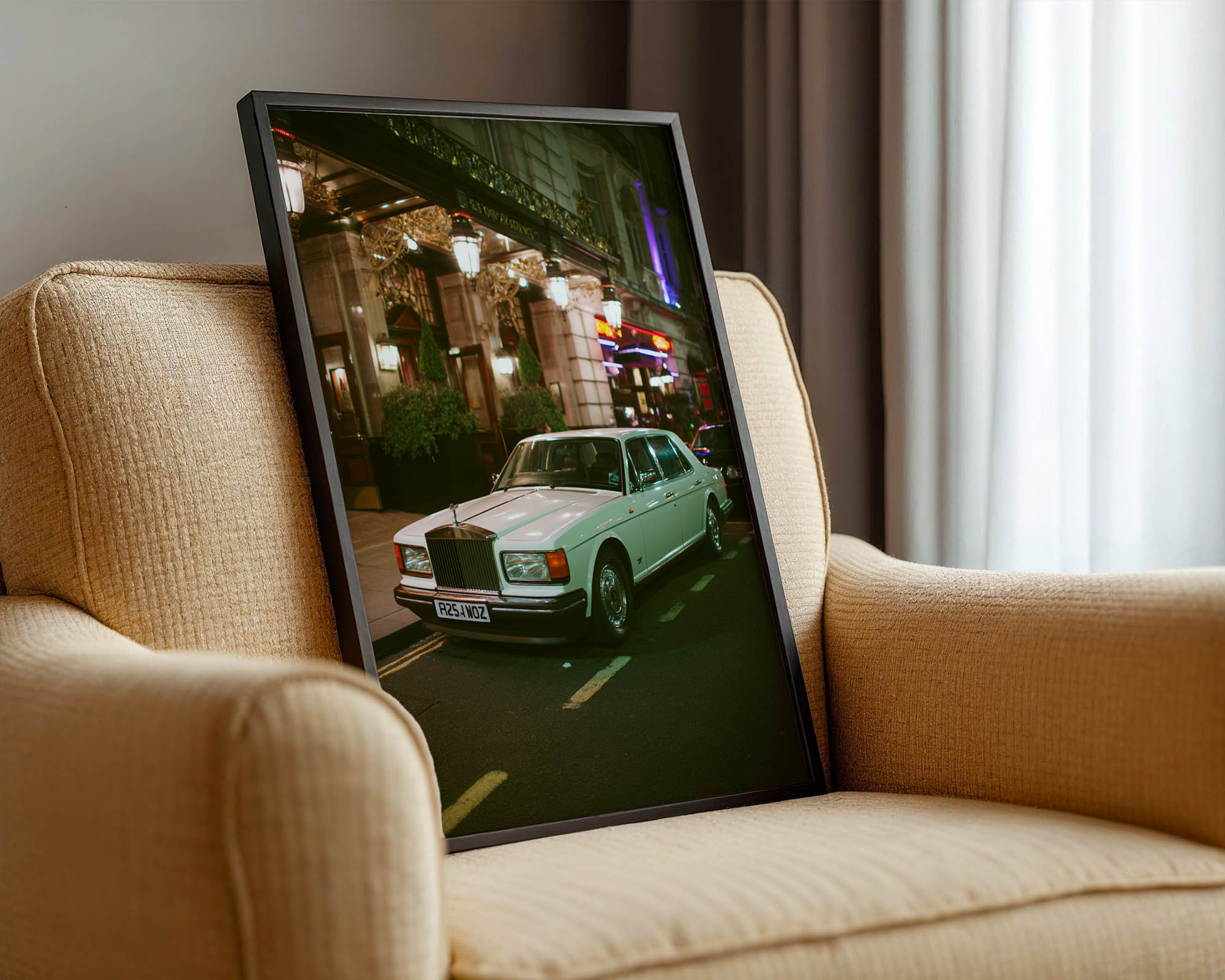 Framed photograph of a vintage car on a beige sofa