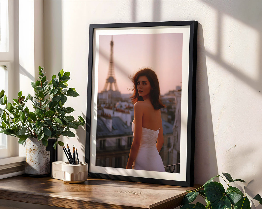 Framed photograph of a woman in a white dress with the Eiffel Tower in the background, placed on a wooden shelf with plants.