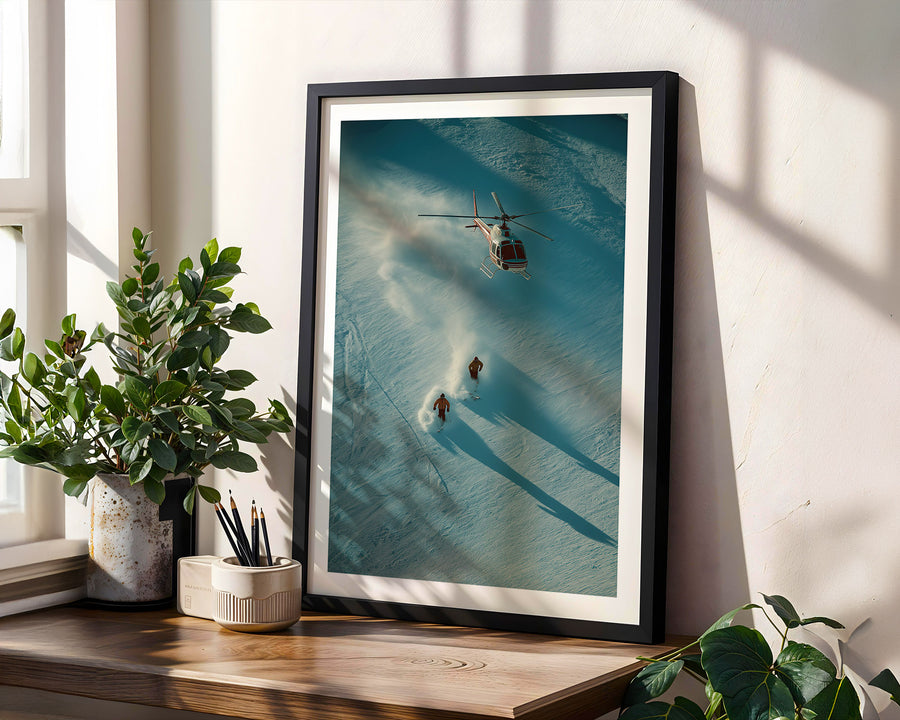 Framed artwork of a helicopter and 2 persons skiing in the Swiss alps.