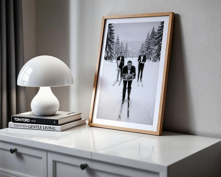 Framed black and white photograph on a shelf with a lamp and books