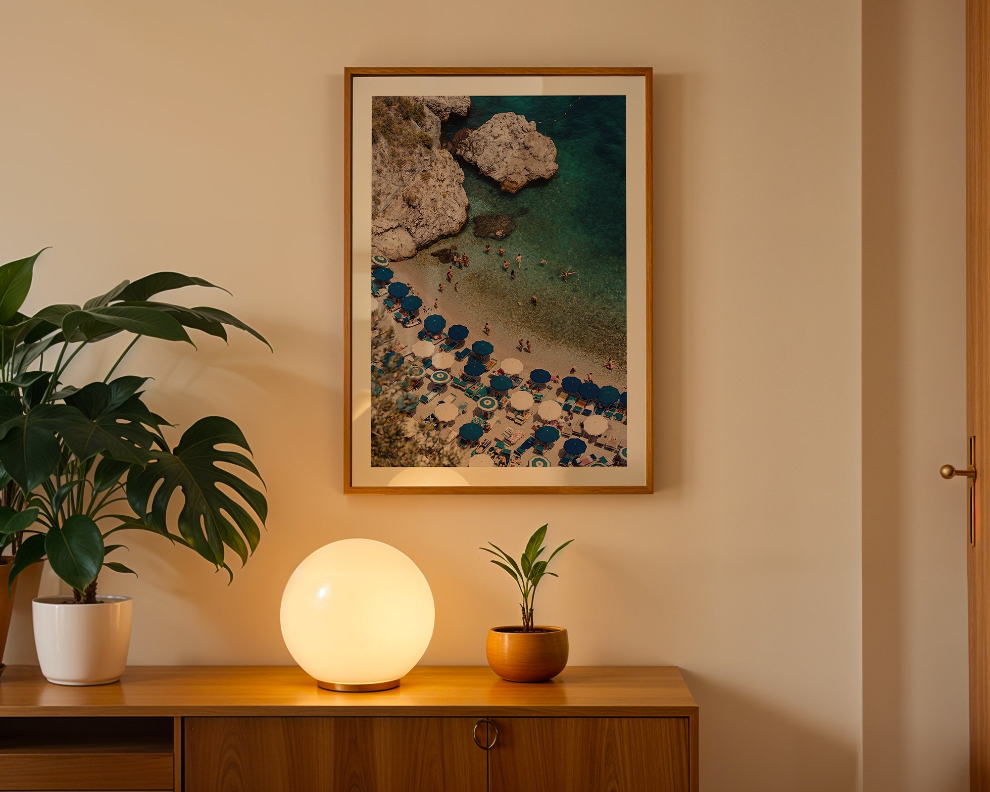 Room interior with a wooden cabinet, decorative lamp, potted plants, and framed artwork on the wall.