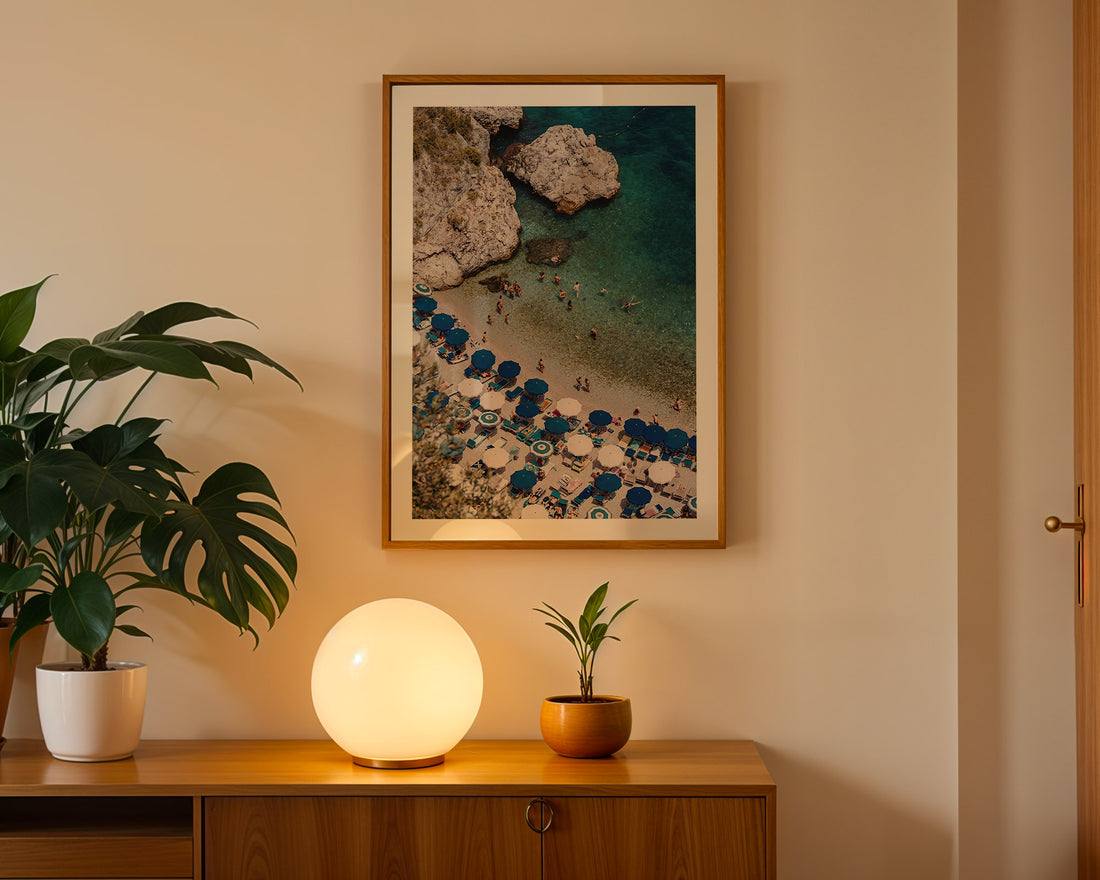 Room interior with a wooden cabinet, decorative lamp, potted plants, and framed artwork on the wall.