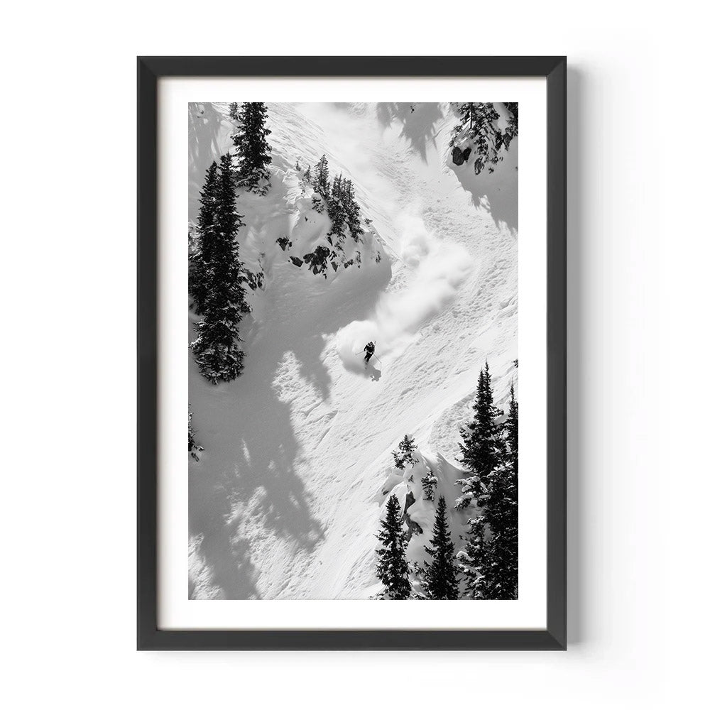 Framed black and white photograph of a skier descending a snowy mountain with trees.