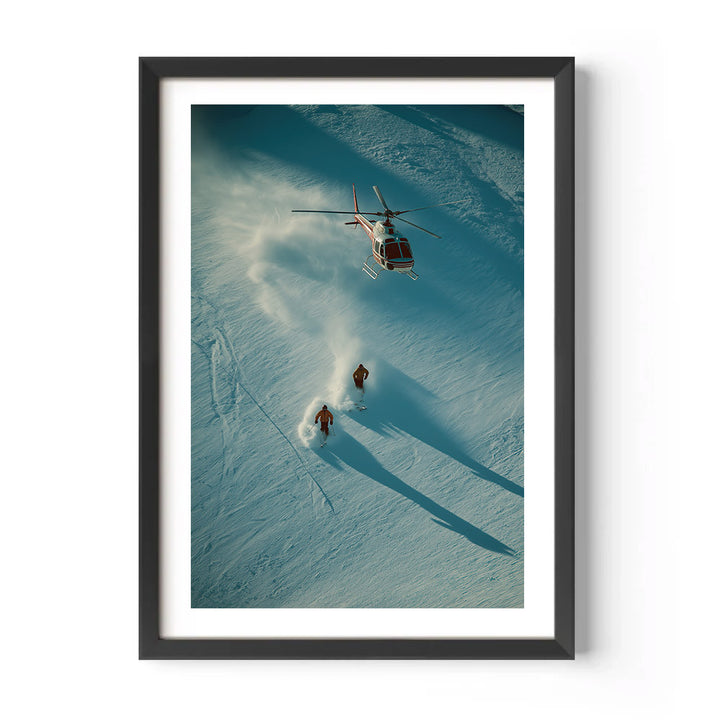 Framed photograph of a helicopter and two people on skis in a snowy landscape.