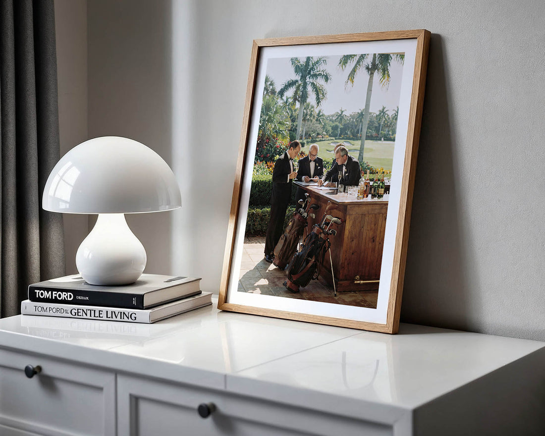 Framed photograph on a white surface with a lamp and books