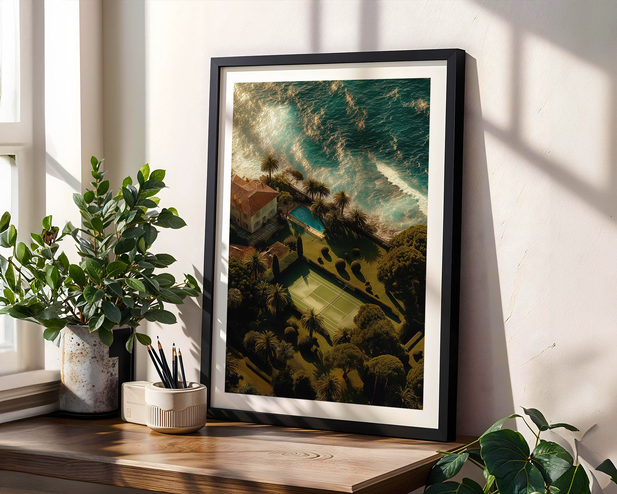 Framed artwork on a wooden shelf with plants