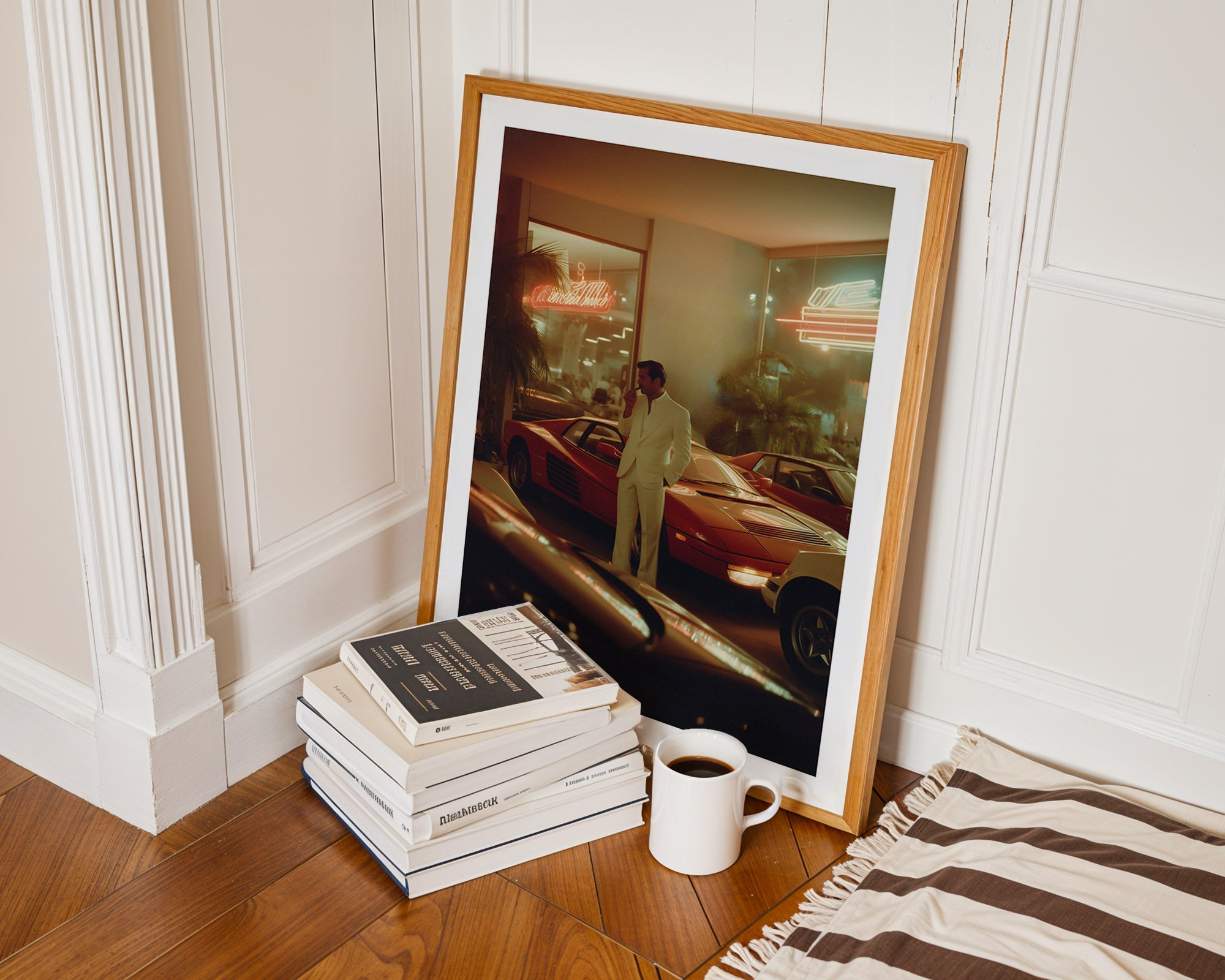 Framed photograph of a man in a car on a wooden floor with books and a mug.