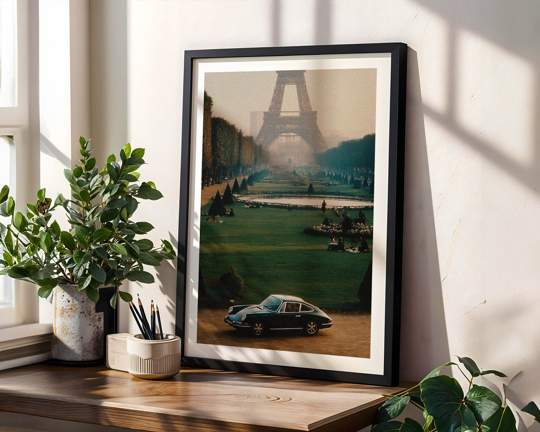 Framed artwork of a cityscape with the Eiffel Tower on a wall with plants around.