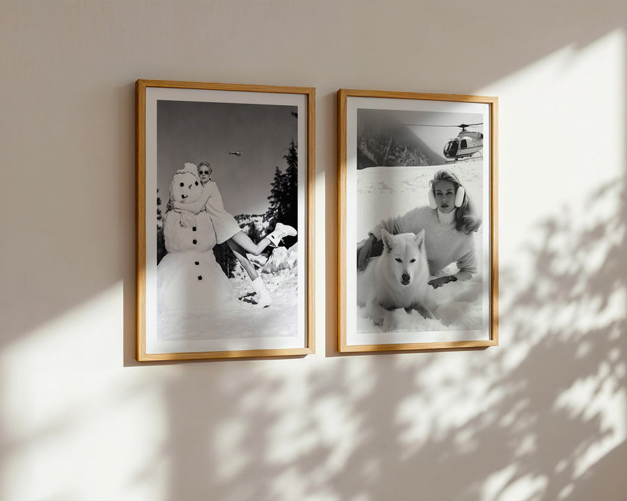 Two framed black and white photos on a wall with sunlight casting shadows.