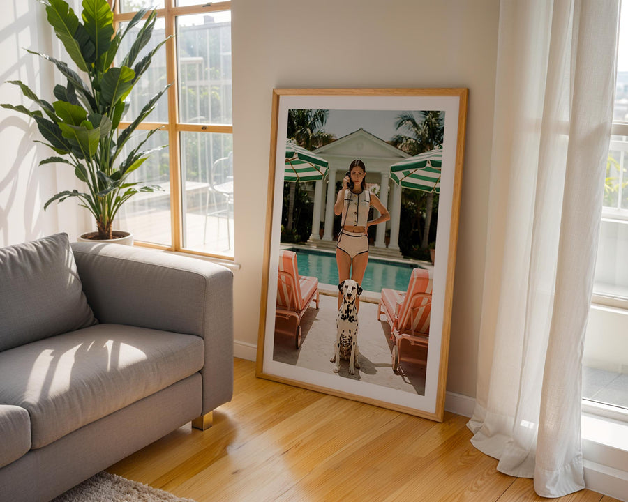 Framed photo of a woman and dog in a living room with a plant and couch.