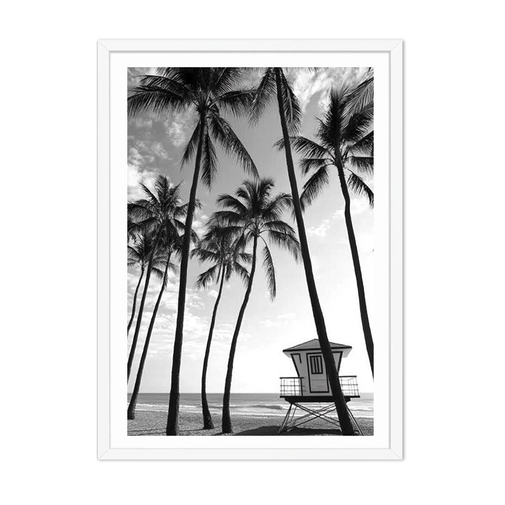Framed black and white print of palm trees and a lifeguard tower on a beach.