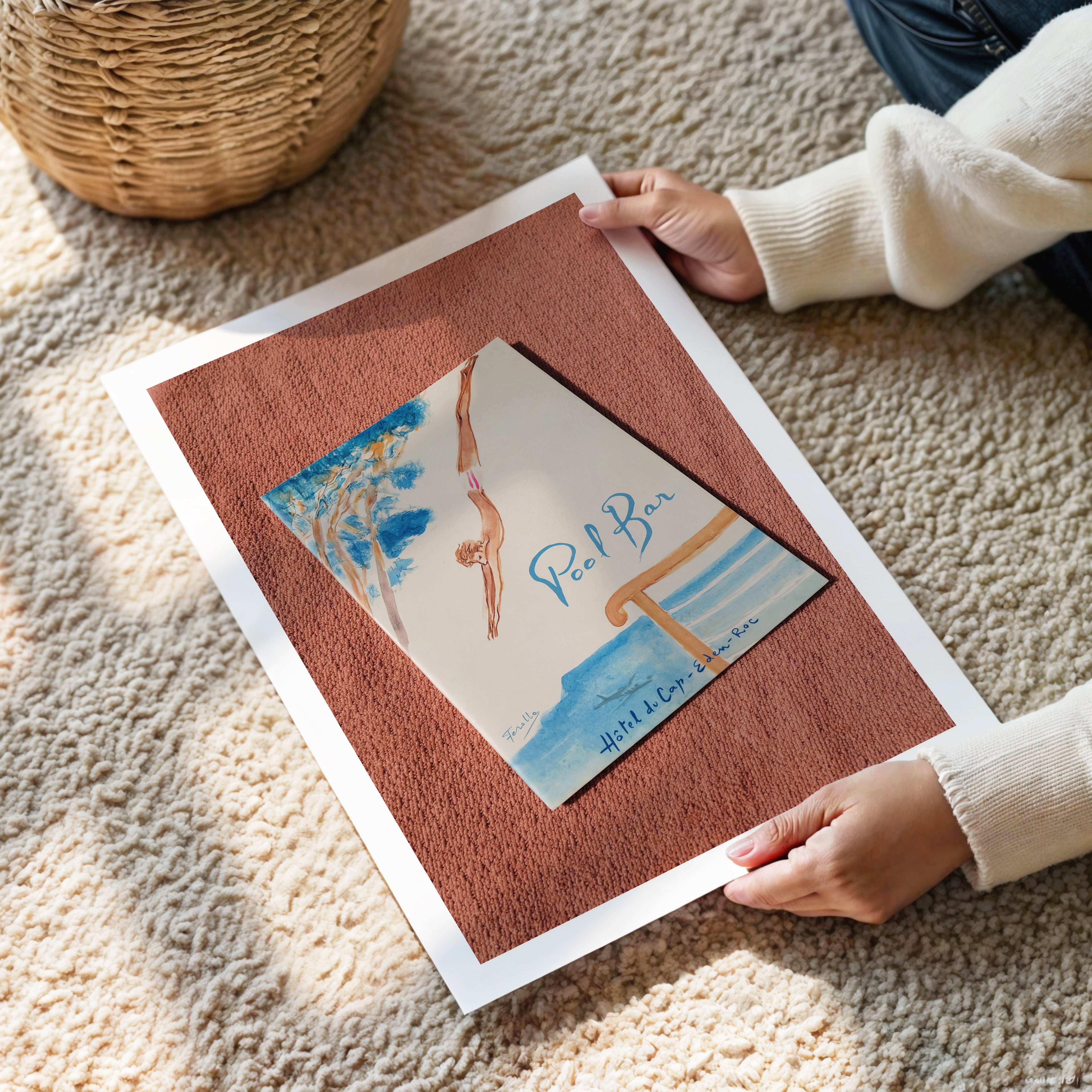Person holding a poster with a menu from Hôtel du Cap-Eden-Roc with a pool bar design on a textured surface