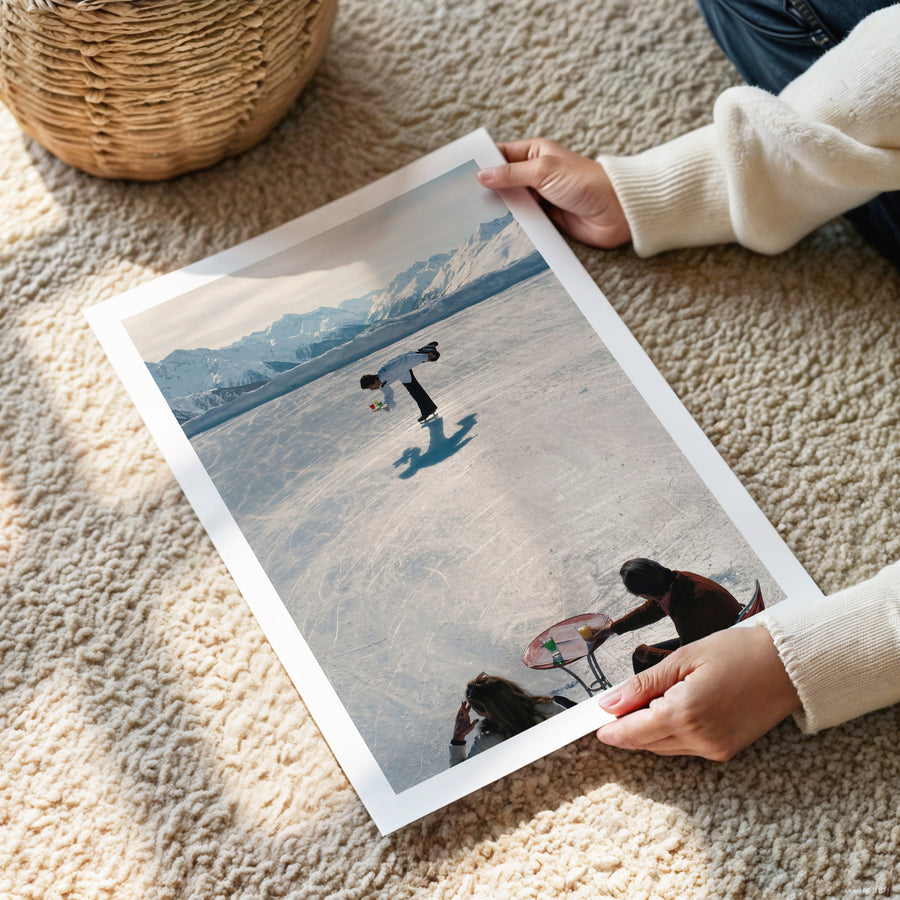 Person holding a large photo of people in Gstaad with mountains in the background.
