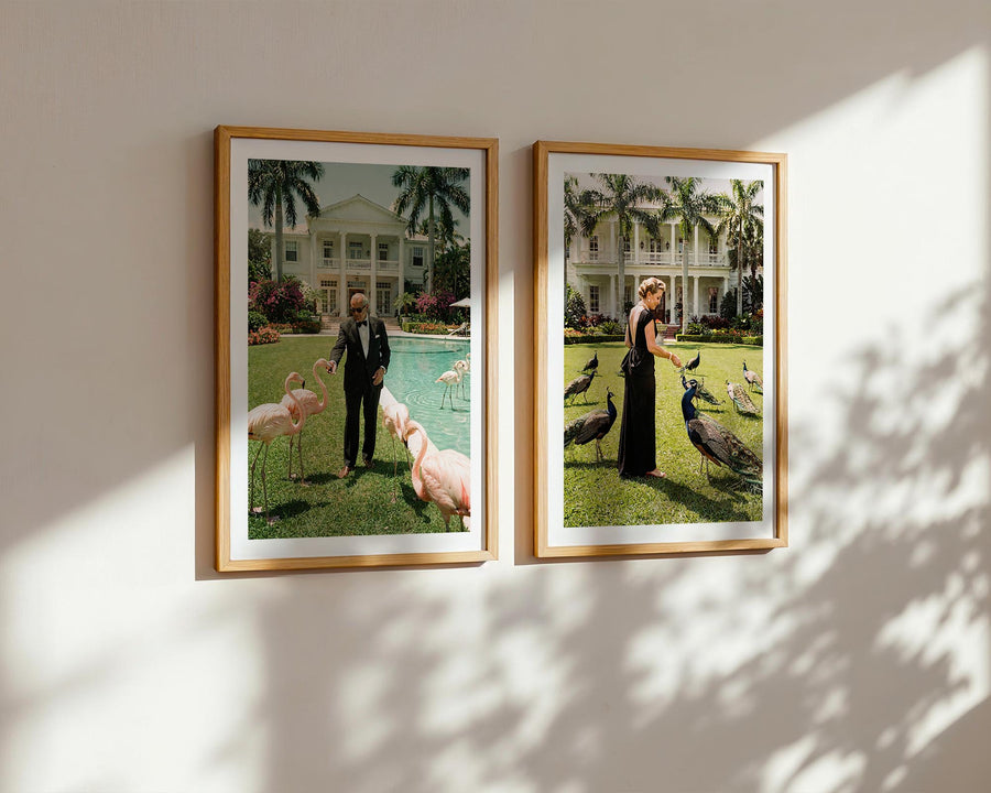 Two framed photographs of people with animals on a wall.