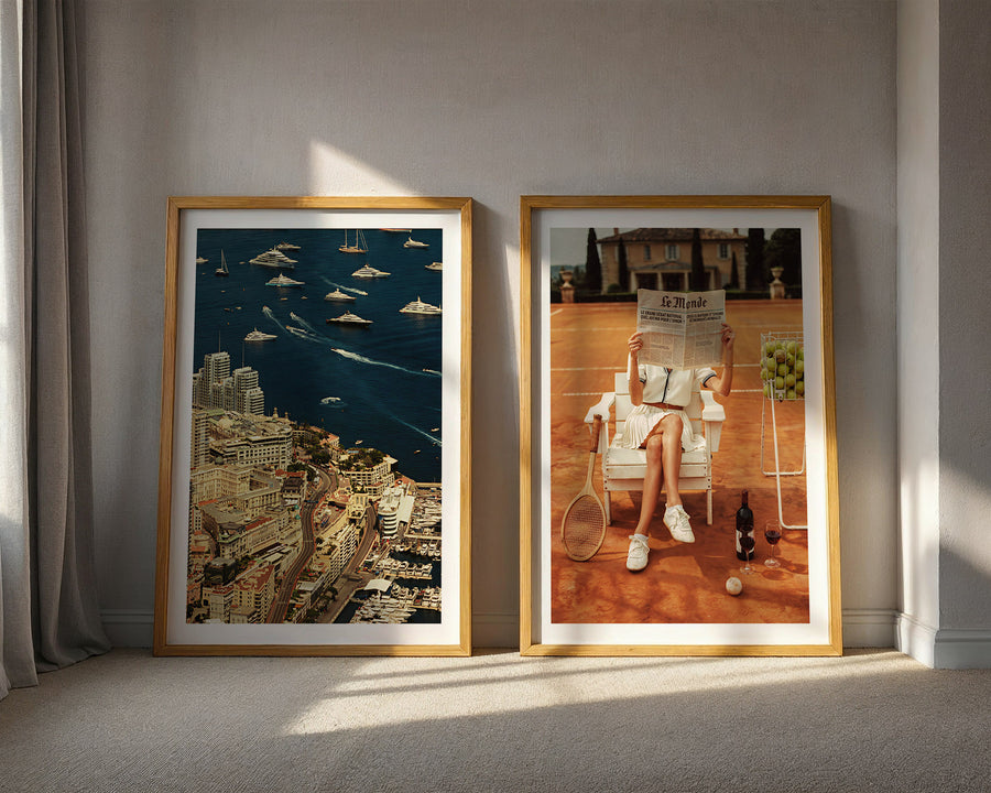 Two framed artworks on a wall with sunlight casting shadows.