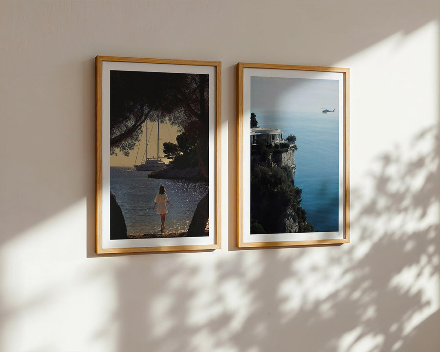 Two framed artworks on a wall with sunlight casting shadows.