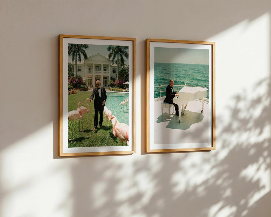 Two framed photographs of a man with animals on a wall with sunlight casting shadows.