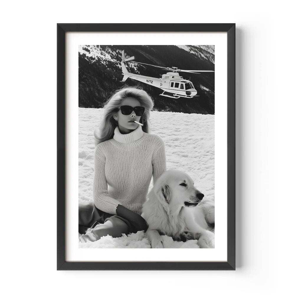 Framed black and white photo of a woman with a dog on a snowy landscape with a helicopter in the background.