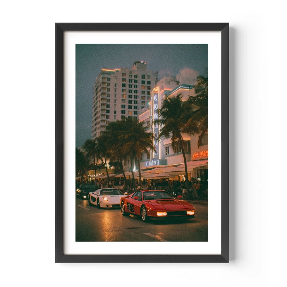Framed photo of a city street at night with palm trees and a red car.