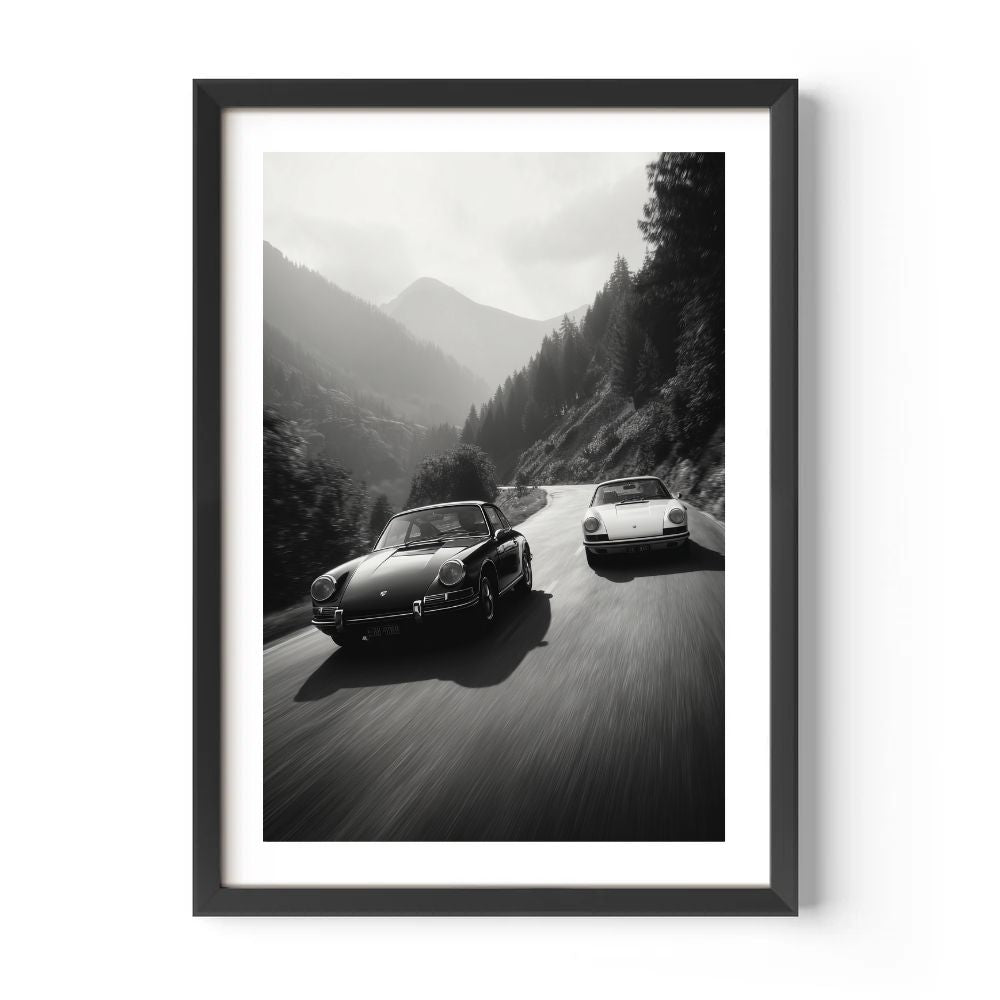 Framed black and white print of two classic Porsches on a mountain road.