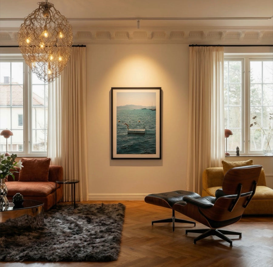 Living room with a chandelier, sofa, armchair, and framed picture on the wall.