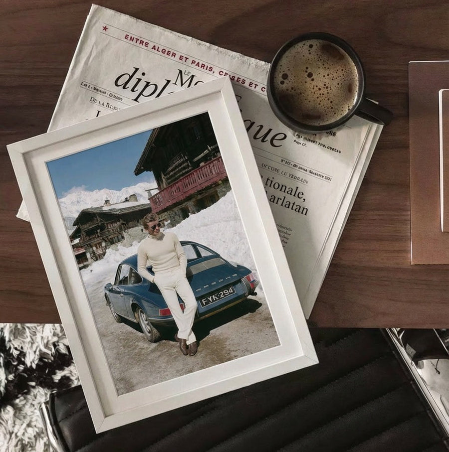 Framed photo of a person with a vintage car on a newspaper with a cup of coffee.