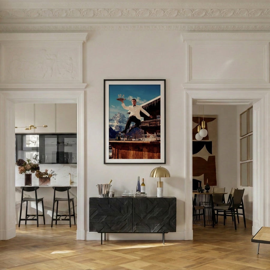 Modern interior with a black sideboard, framed picture, and open kitchen.