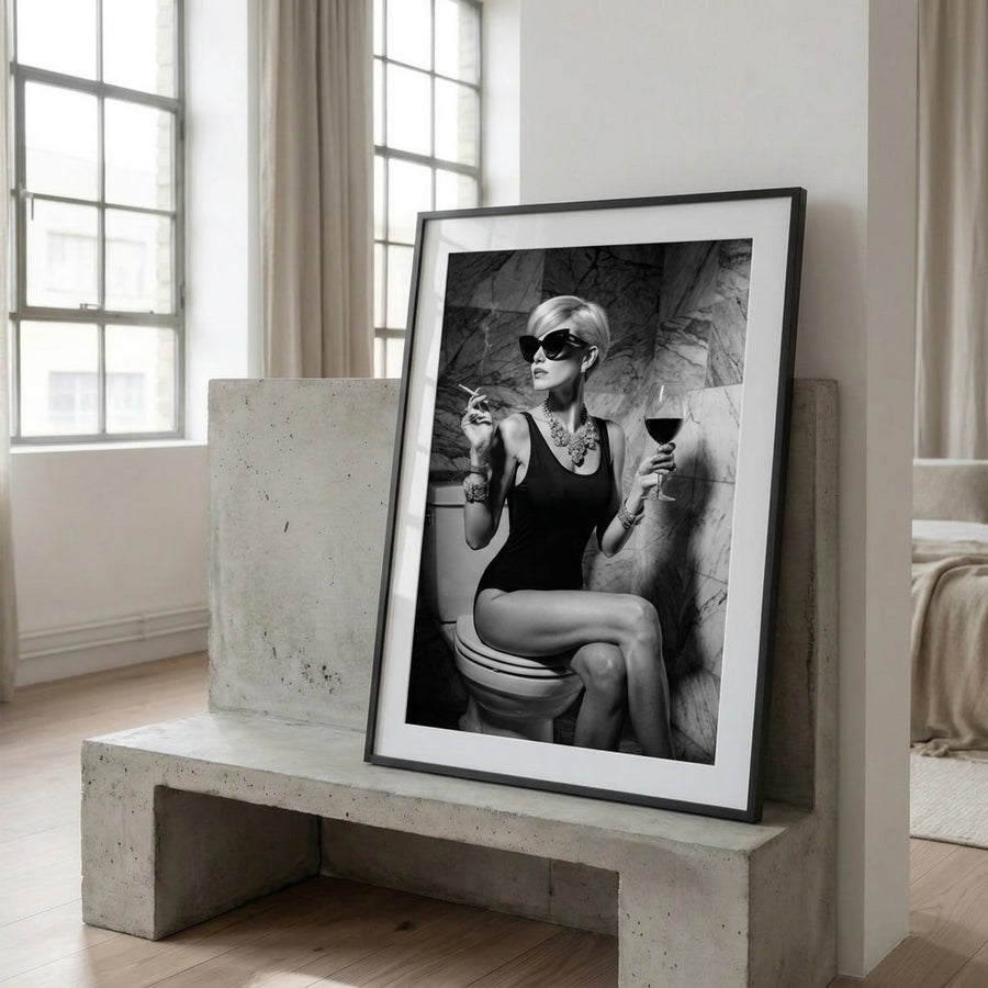 Framed black and white artwork of a woman on a toilet in a modern room.
