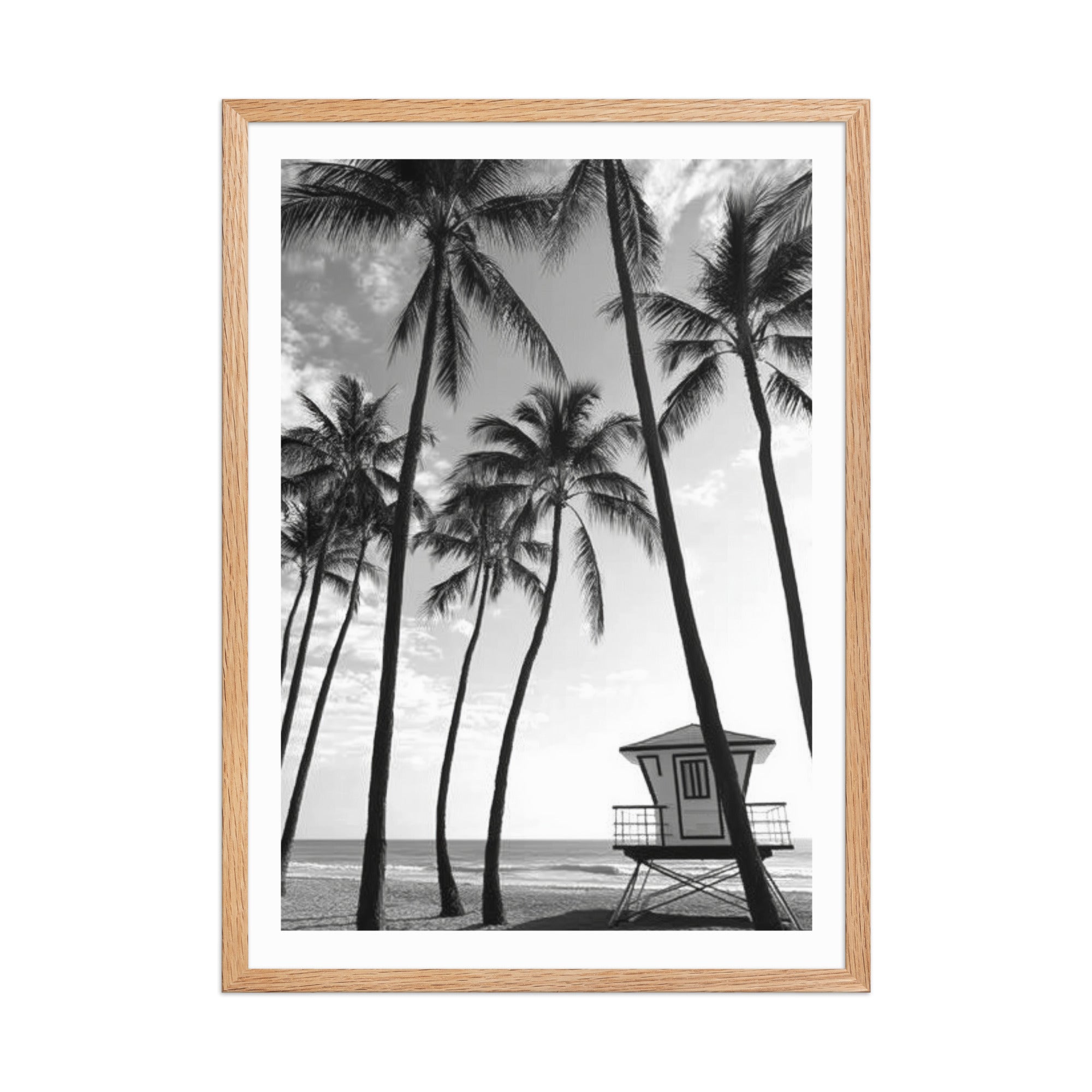 Framed black and white print of palm trees and a lifeguard tower on a beach.