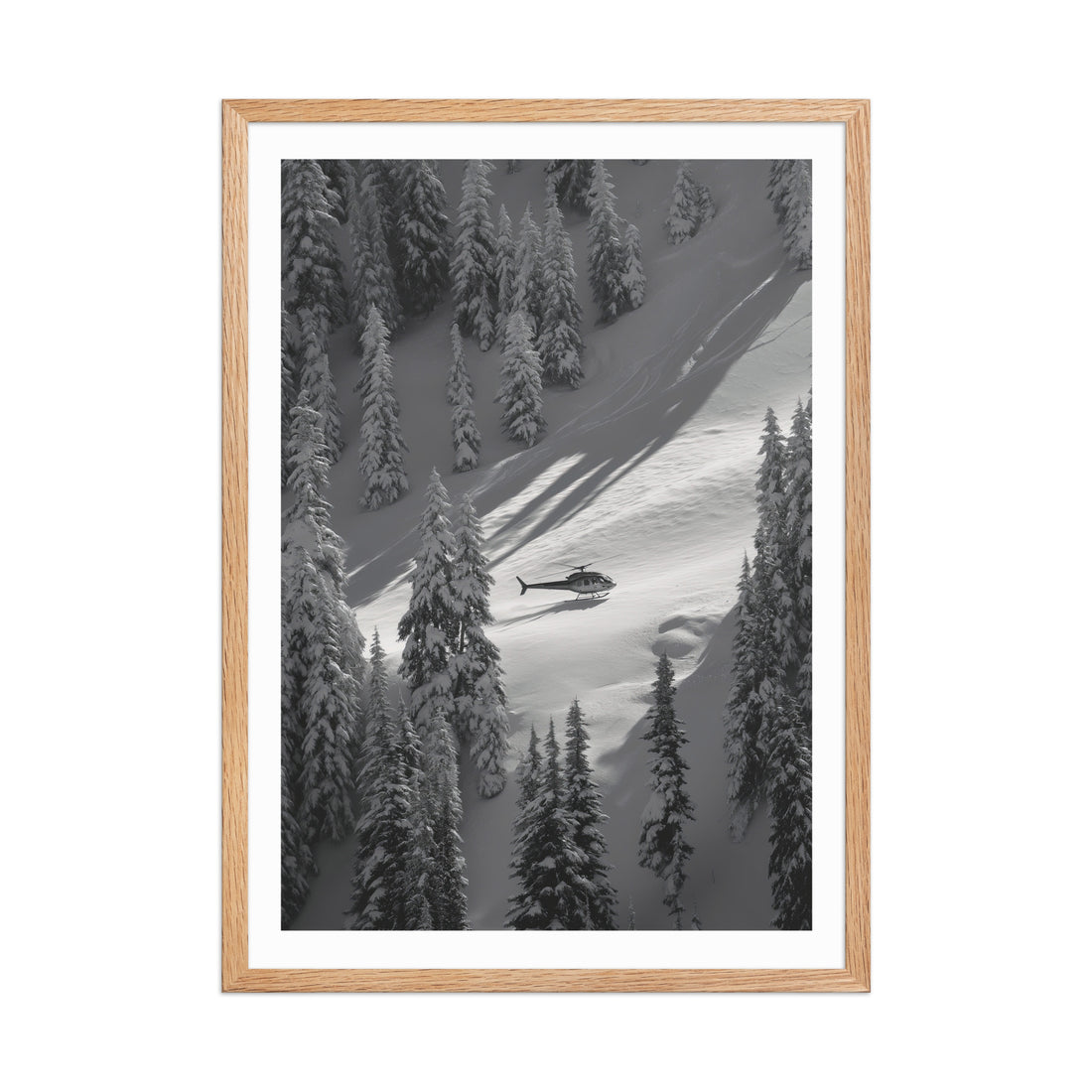 Framed black and white photograph of a helicopter in a snowy forest landscape.