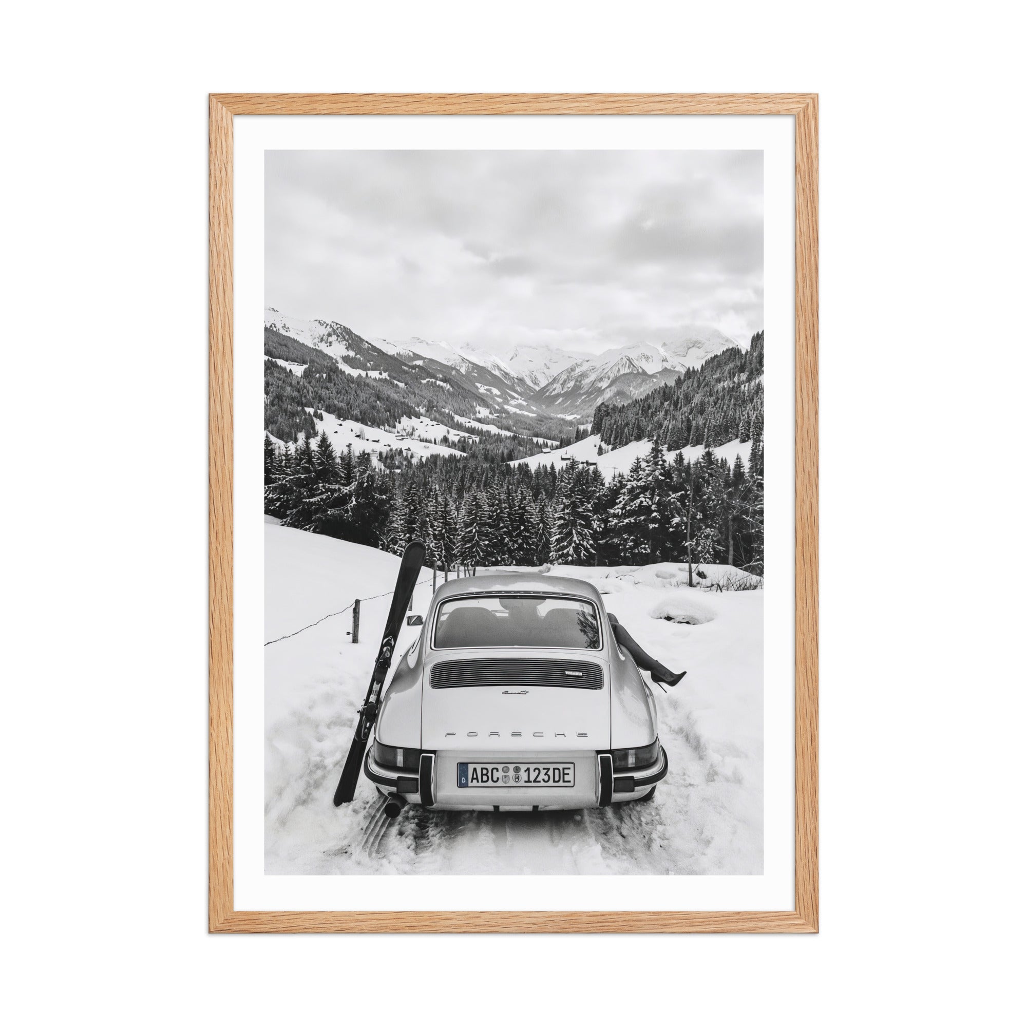 Framed black and white photo of a 911 Porsche in a snowy mountain landscape