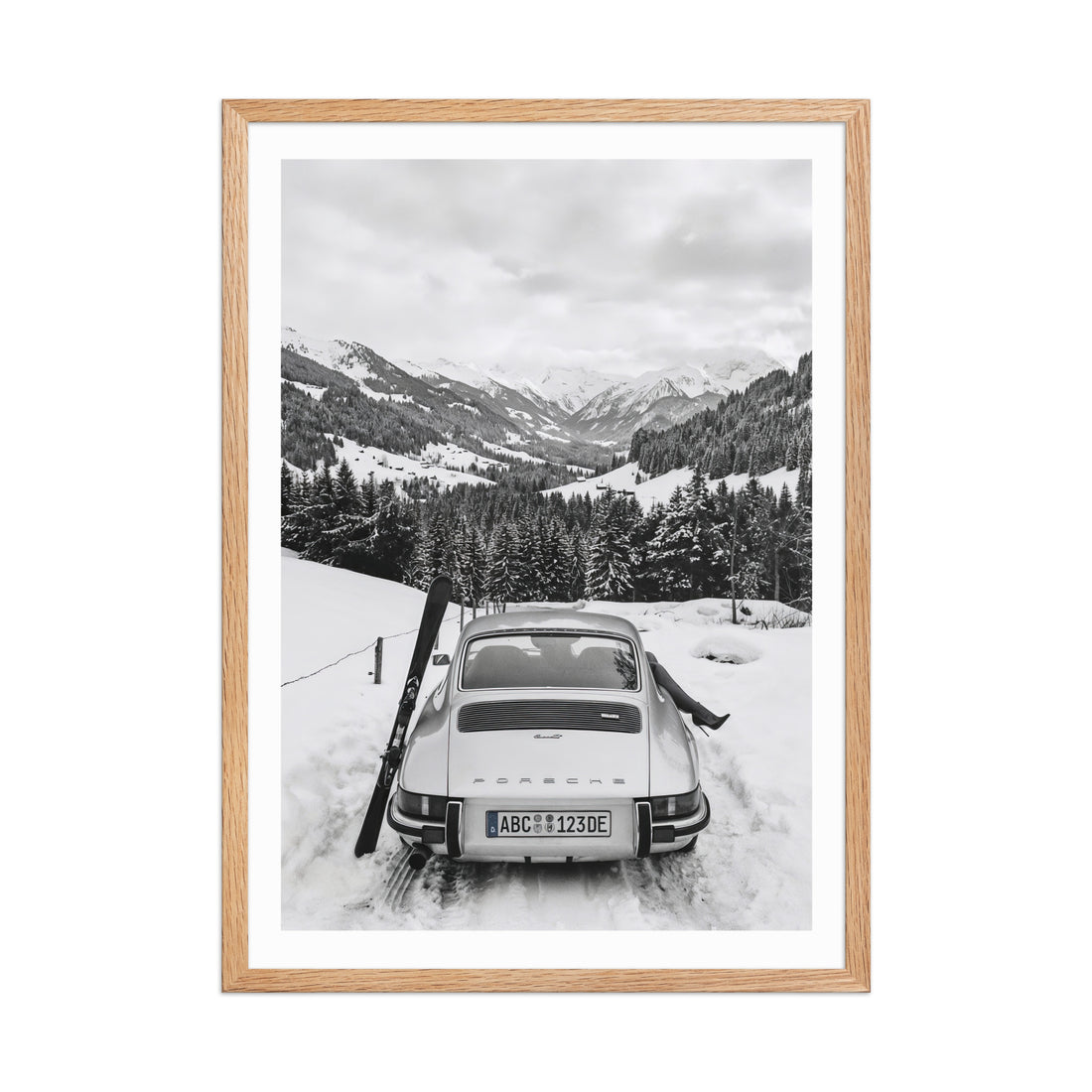 Framed black and white photo of a 911 Porsche in a snowy mountain landscape