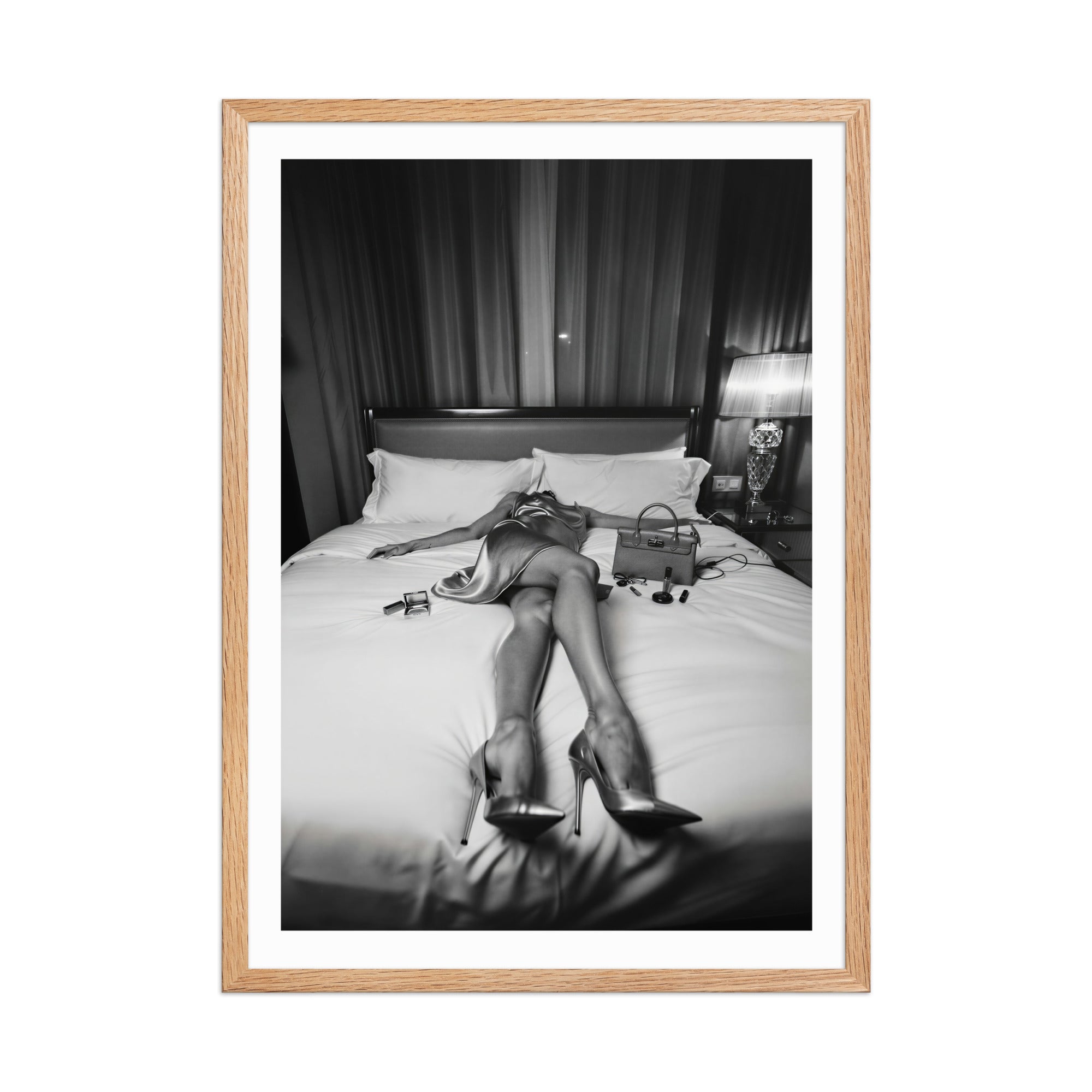 Framed black and white photo of a person in high heels on a bed.