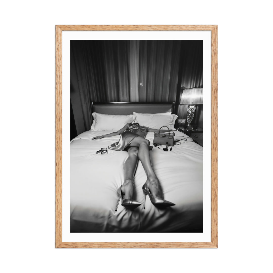 Framed black and white photo of a person in high heels on a bed.