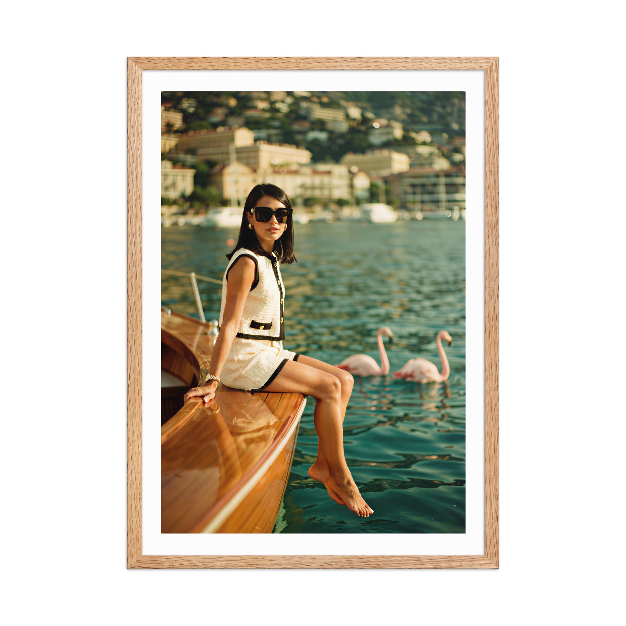 Framed photograph of a woman sitting on a boat with swans in the background