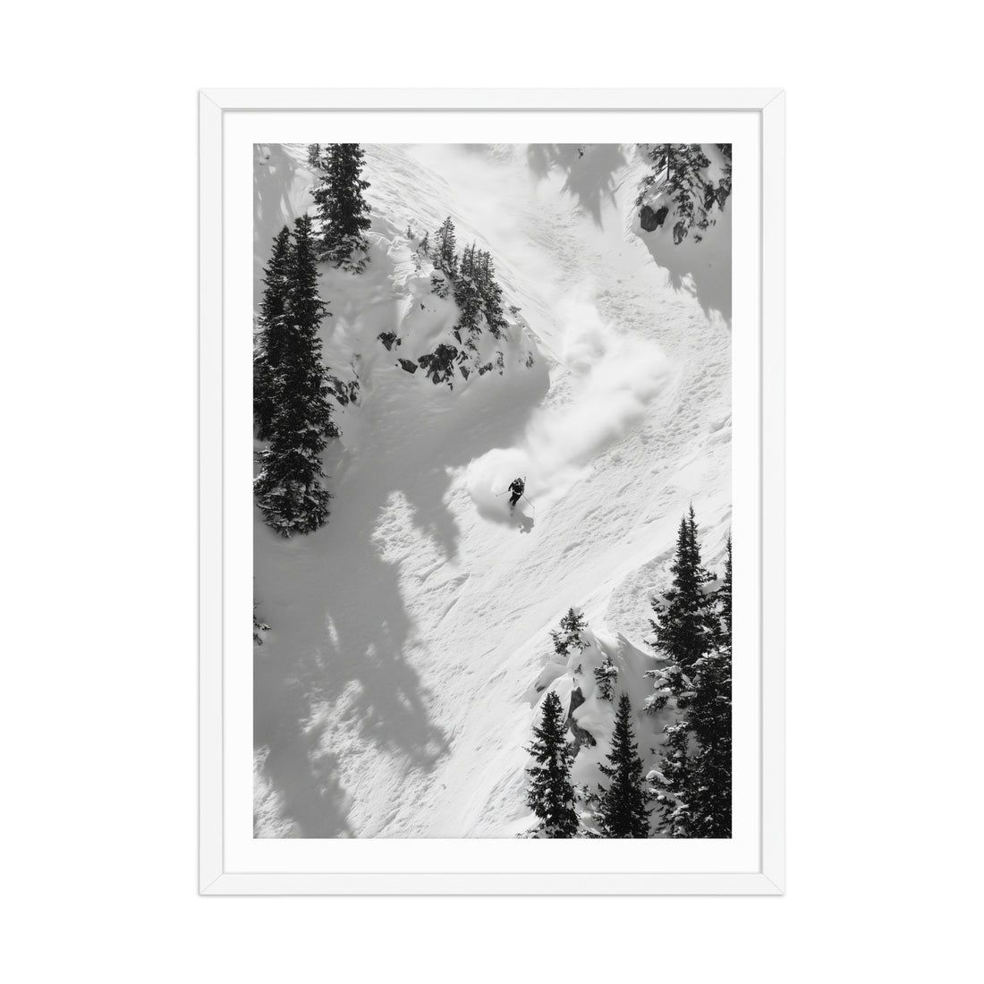 Black and white photograph of a skier descending a snowy mountain with trees.