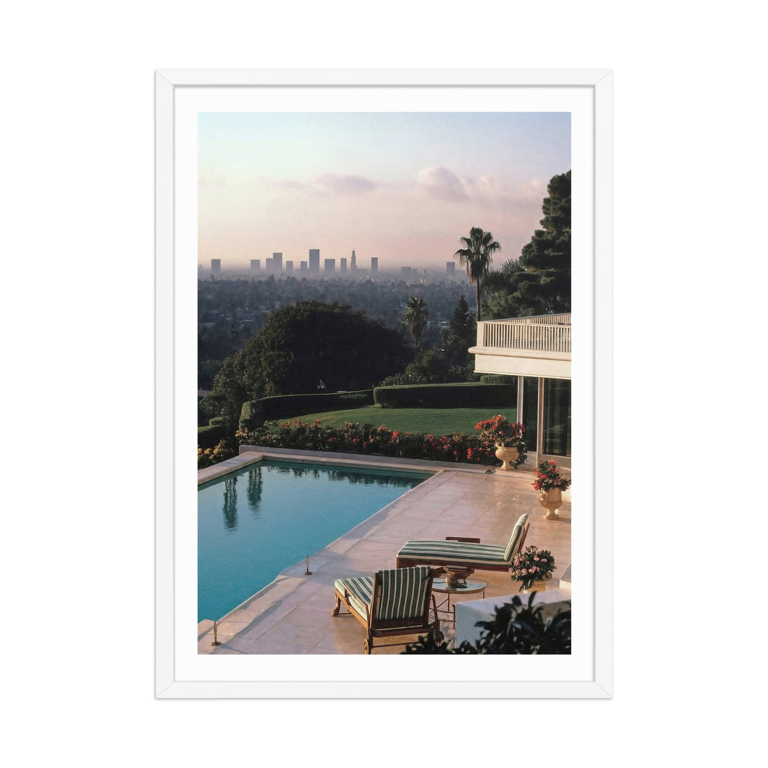 Framed photograph of a poolside scene  in Los Angeles with lounge chairs and a city skyline in the background.