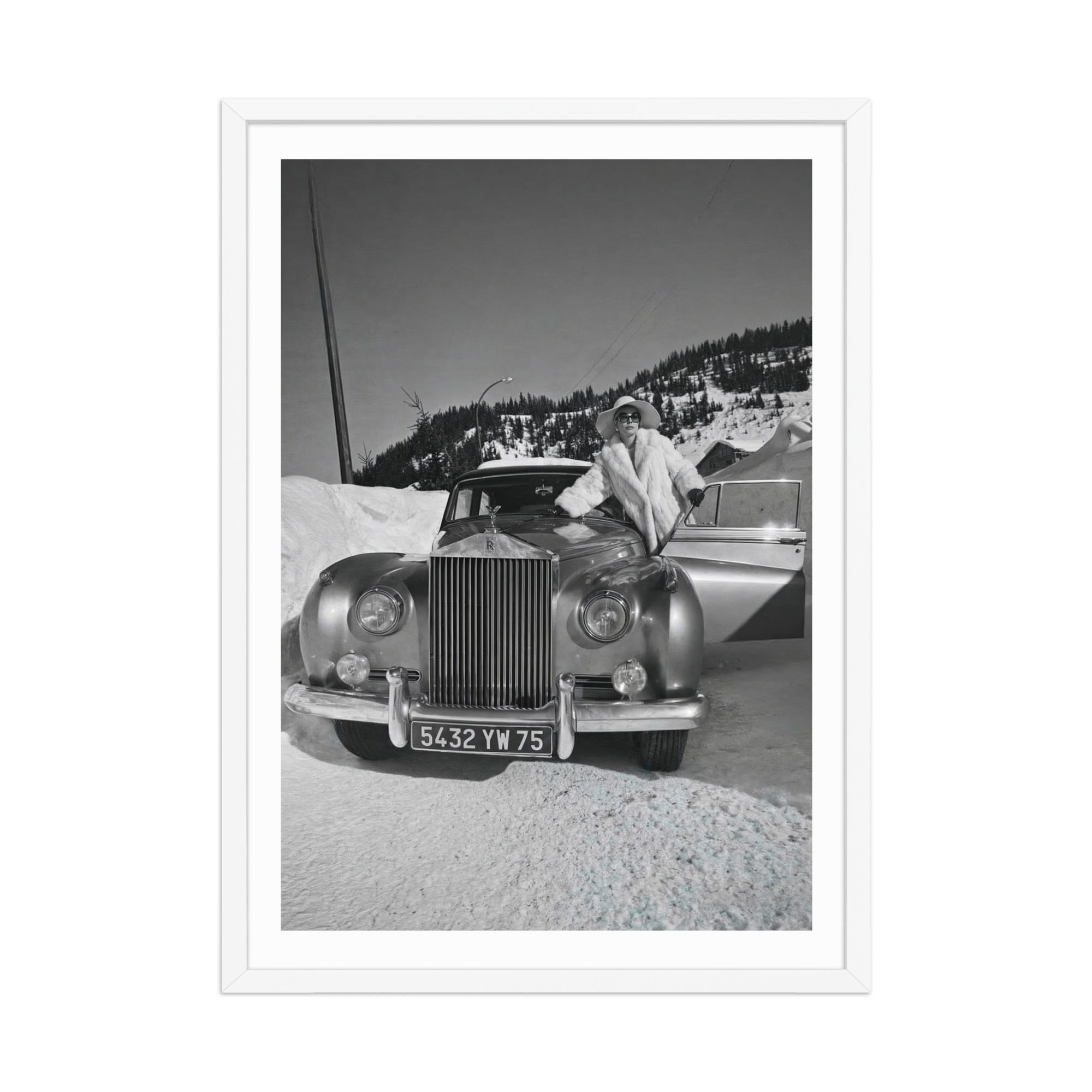 Vintage car in a snowy landscape with a person standing next to it, framed in white.