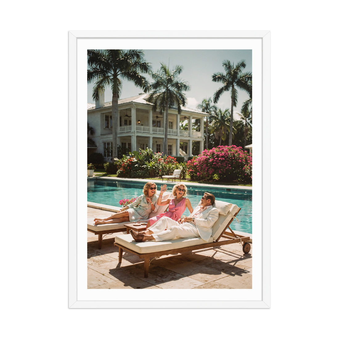 Three people sitting by a pool with palm trees and a large house in the background.