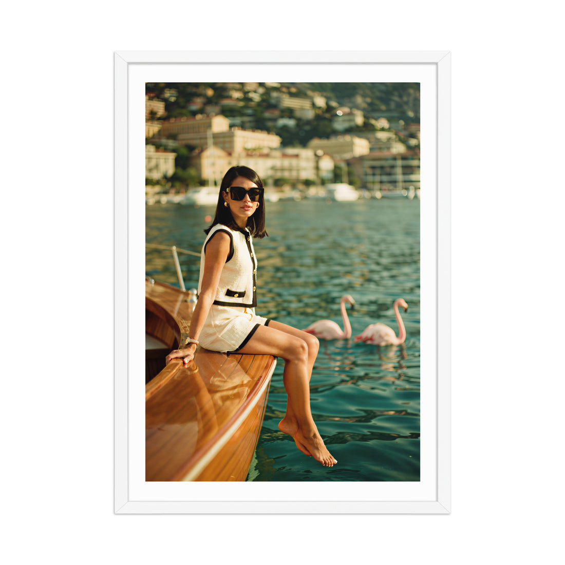 Woman sitting on a boat with flamingos in the water, framed photo